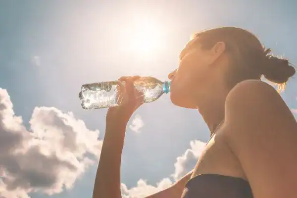 Hydration: The Secret Ingredient for a Toned Stomach and Enhanced Fitness 3 Image of woman drinking water to hydrate Ayr after run.